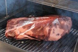 Brisket Wrapped and Smoking in Pink Butcher Paper